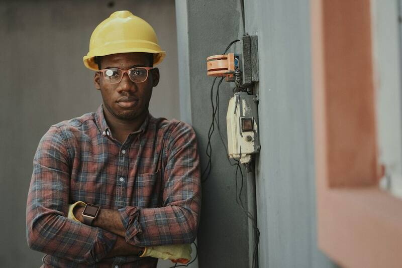 Technician standing beside a serviced outdoor heating and cooling unit