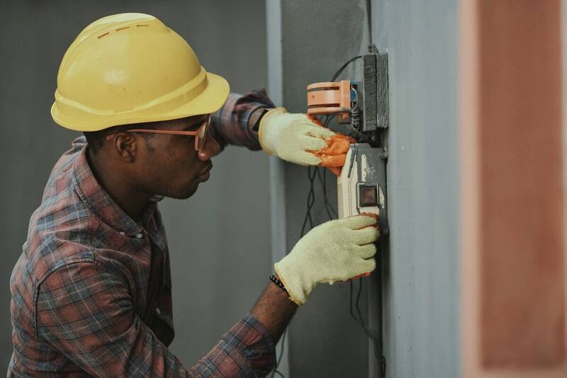 Technician installing and adjusting a wall-mounted heat pump unit